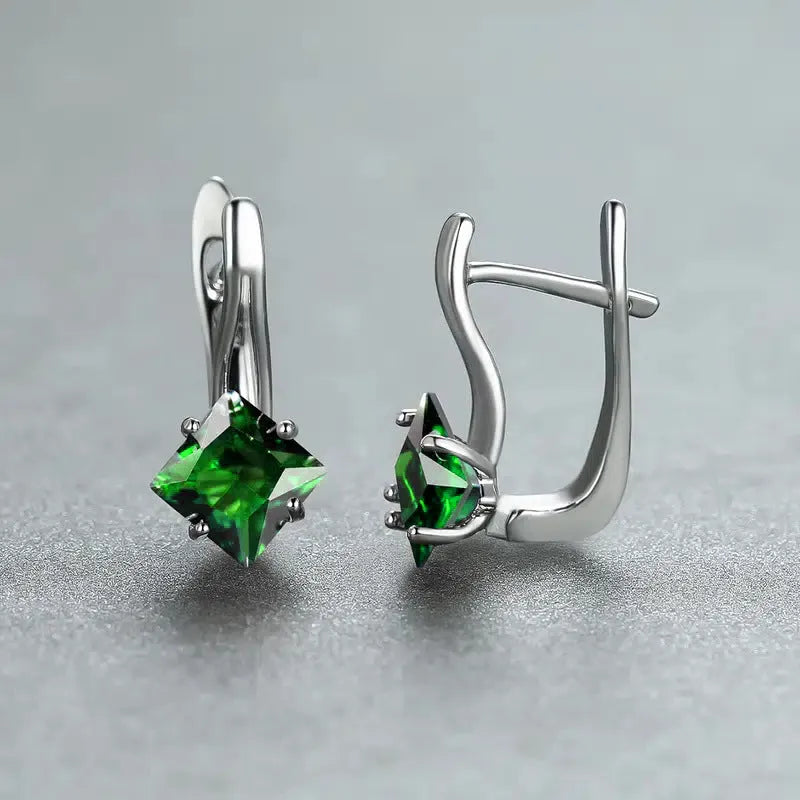 A pair of copper diamond design earrings for women with inlaid zircon stones, shown in blue, green, and a metallic colour.