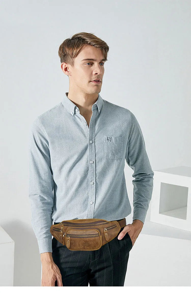 Brown leather messenger bag with a single shoulder strap shown open on a table