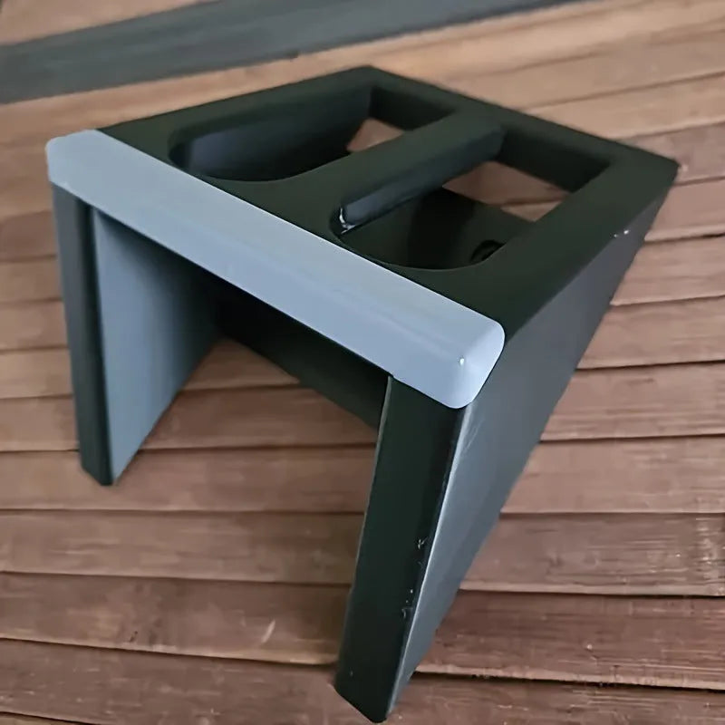 Matte black plastic pistol display stand with a punk-style design on a flat surface.