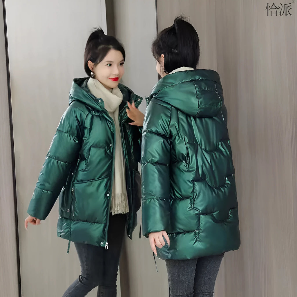 Green loose thick women's winter hooded jacket with long sleeves on a hanger.