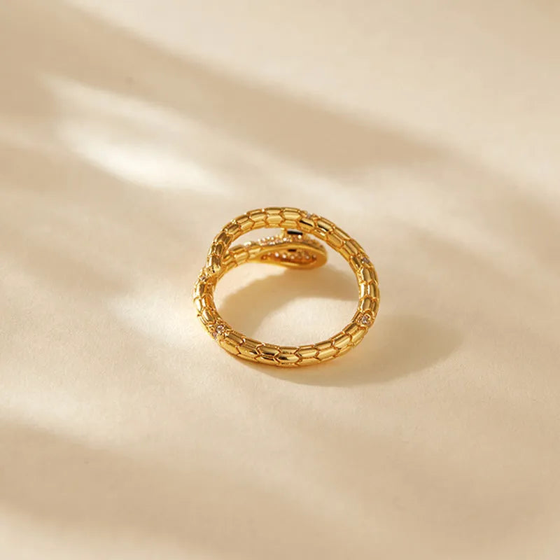 Snake-shaped adjustable copper ring with 18K gold colour retention plating on index finger