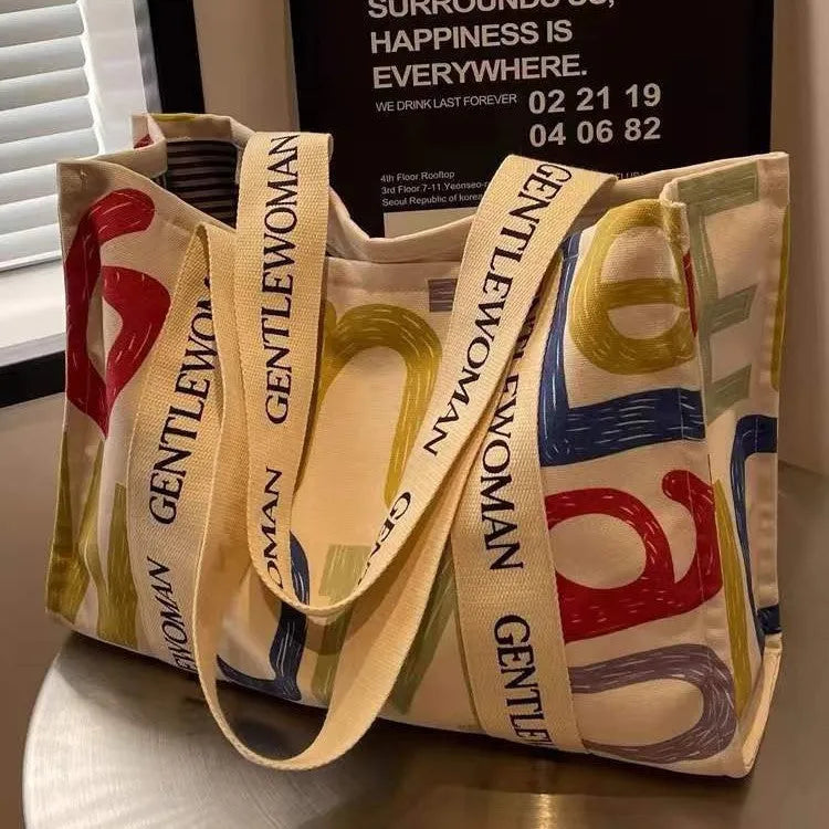 Large canvas tote bag with printed design options including letters and patterns.