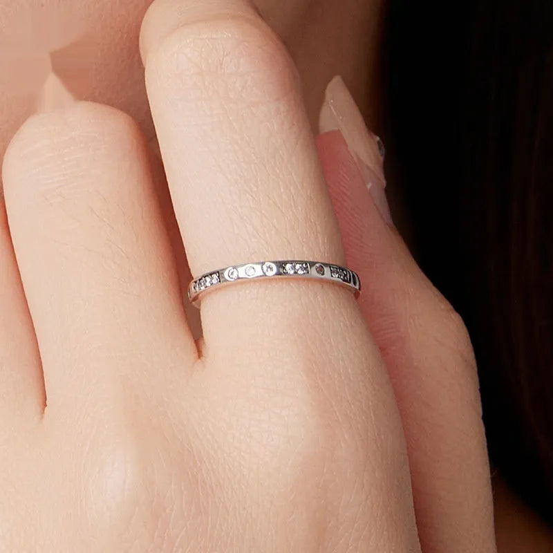 Moss Password I Love You silver ring with oxidised black finish on a model's finger, showing simple bracelet style.