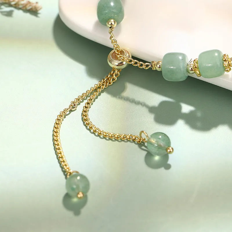 Rabbit charm bracelet with green aventurine and strawberry quartz stones on copper metal with gold accents