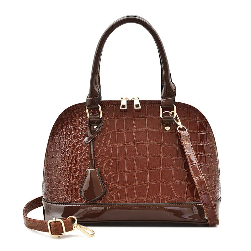 Large shiny black PU leather crossbody bag with shell shape, showing interior polyester lining and shoulder strap