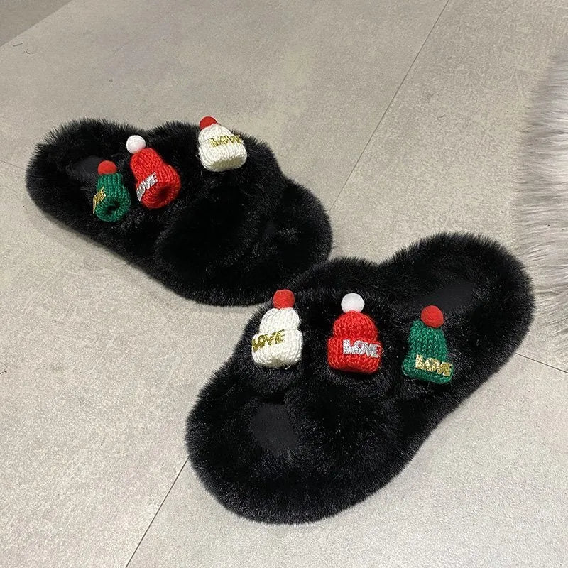 Women's black Christmas slippers with a large hairy decoration on the front, showing faux plush upper.
