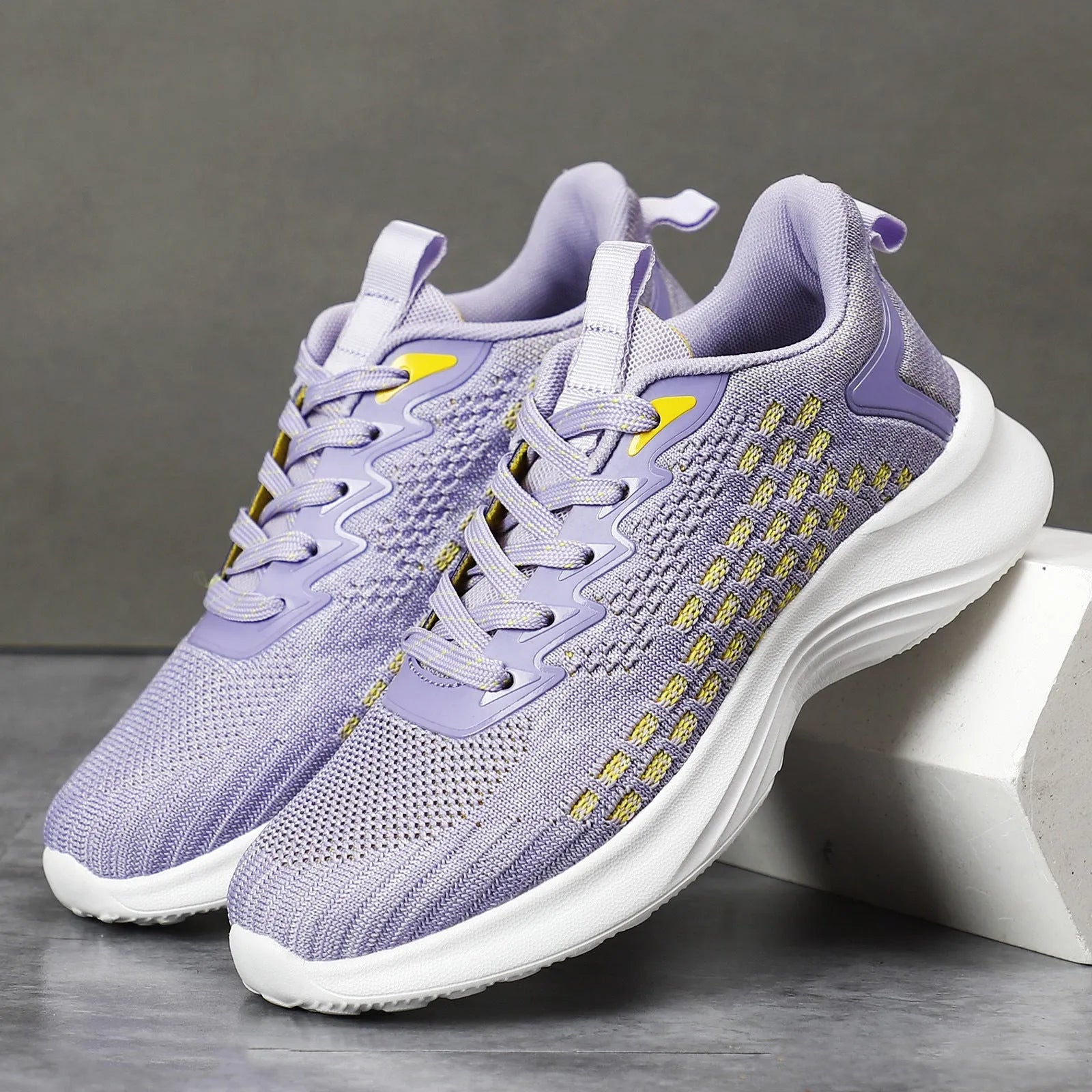 Women's lavender purple Flyknit running shoes with mesh lining and EVA sole on a white background.