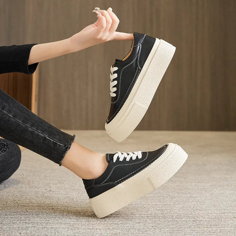 Women's black embossed leather platform sports shoes with round toe and white rubber sole on a white background.