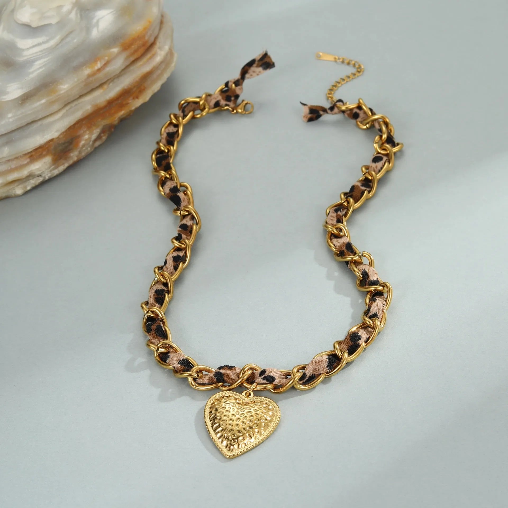 Leopard Love stainless steel necklace with geometric heart or sun pendant on a gold plated adjustable chain.