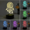 Black-based acrylic dream catcher night light with remote control on a table next to USB cable.