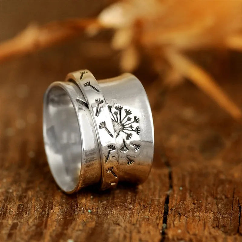 Silver rotatable flower ring on hand showing spinning floral design