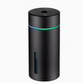 Black aluminium car humidifier diffuser with night light on a desk next to USB cable