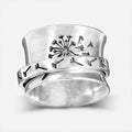 Silver rotatable flower ring on hand showing spinning floral design