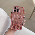 Silver electroplated iPhone 17 Pro Max case with raised three-dimensional wave stripe pattern on the back.