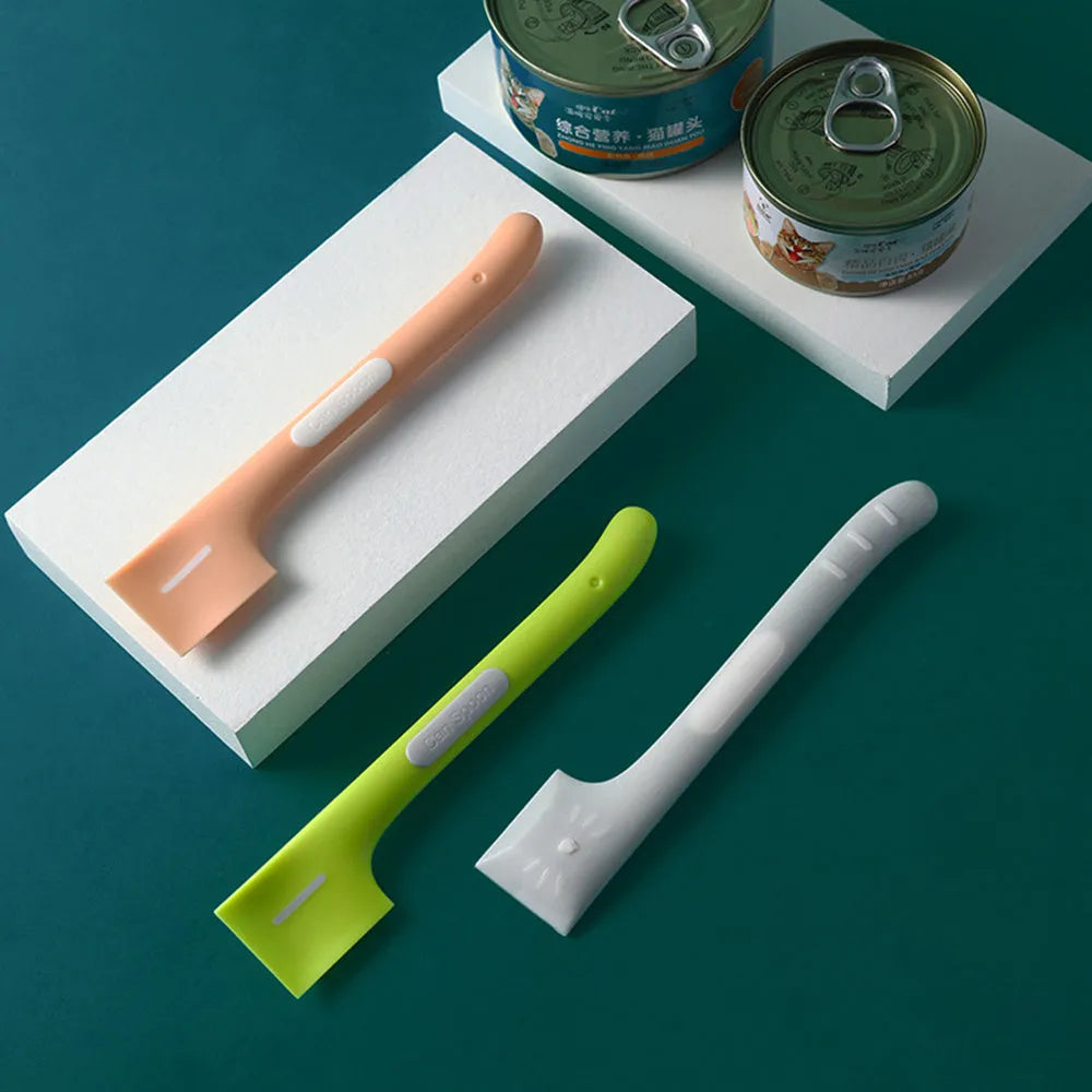Green long-handled pet feeding spoon for scraping wet food from cans.