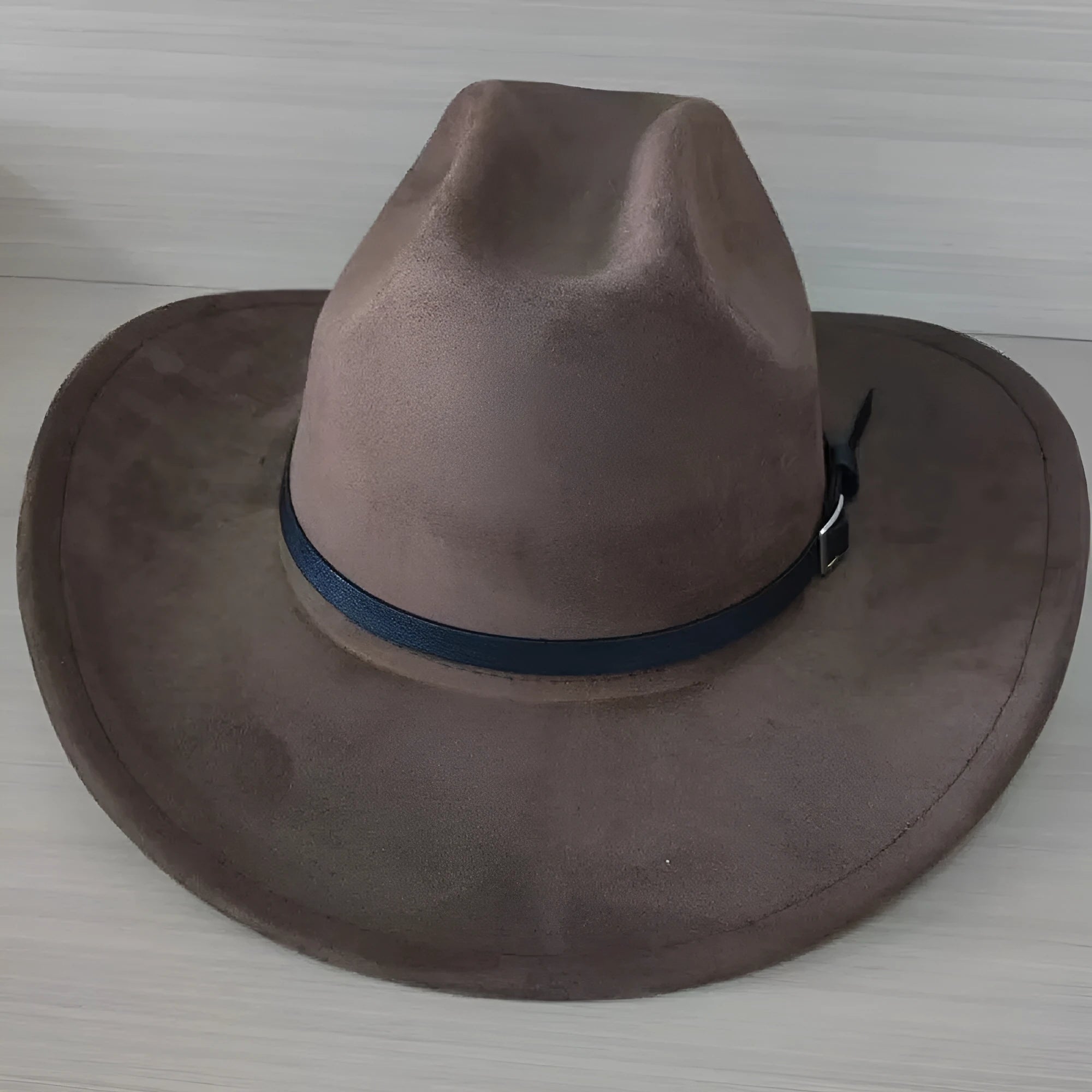 Brown leather velvet cowboy hat with a curved brim and conical crown on a neutral background.