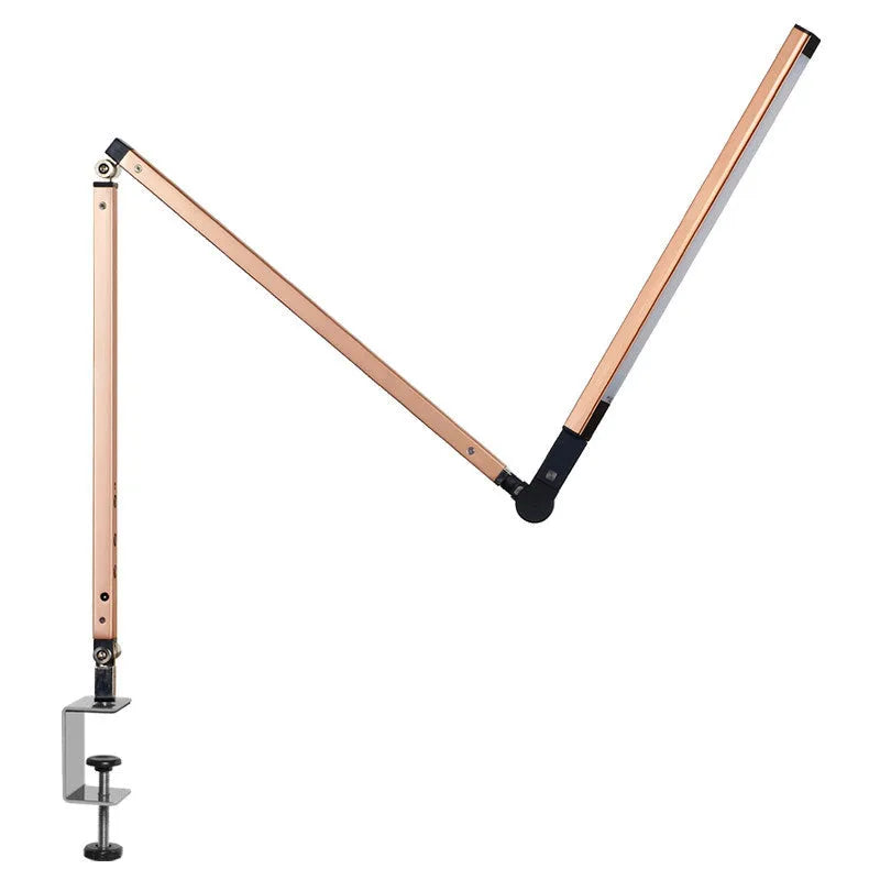 Aluminium LED desk lamp with a folding clip, remote control, and black finish on a desk.