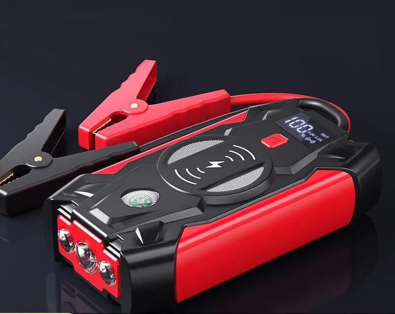Red 12V portable car jump starter power bank with battery clips on a black background.
