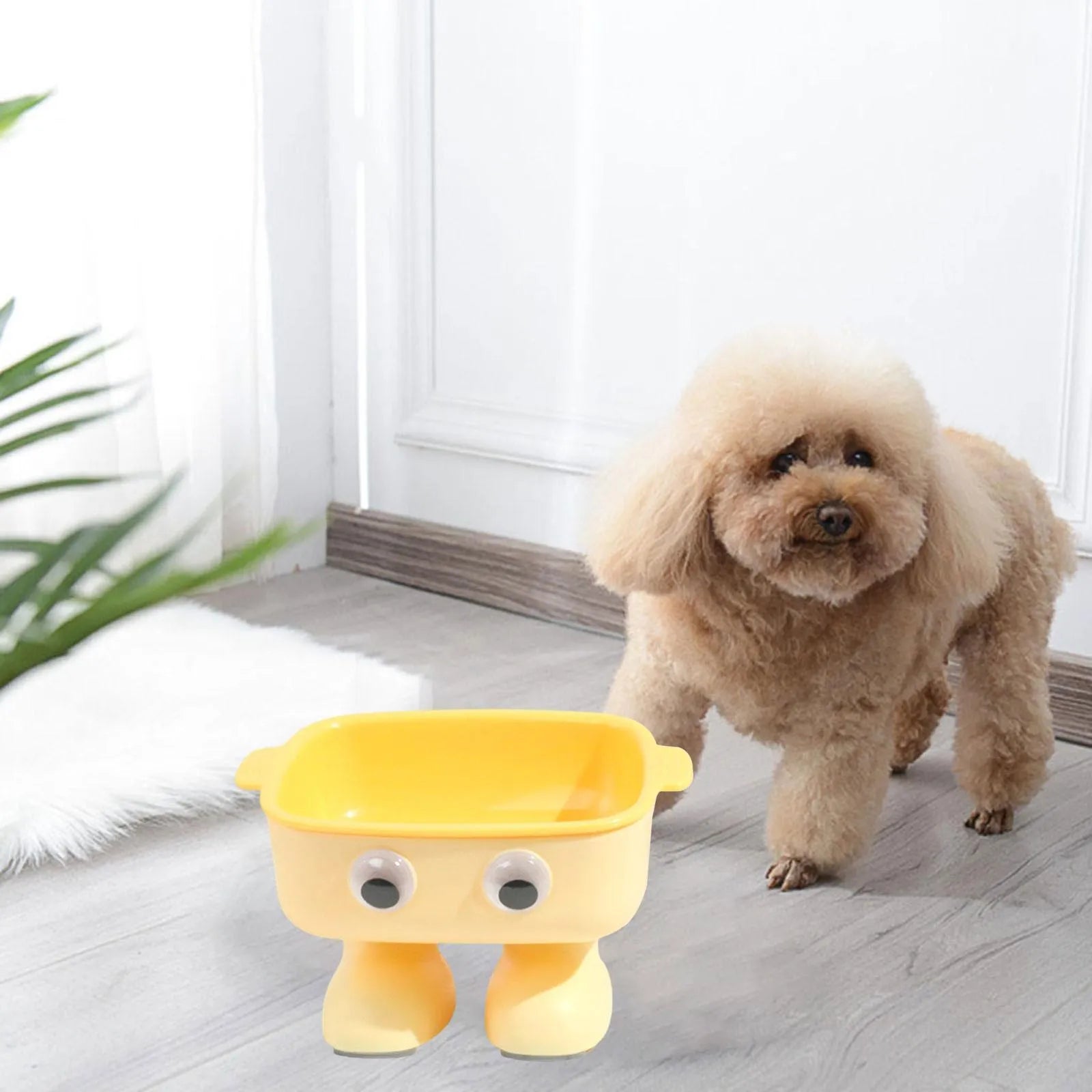 Green cartoon robot-shaped elevated cat bowl with tilted design and non-slip base on a table.