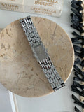 Women's silver and gold bracelet-style vintage watch with 15mm dial and butterfly clasp.