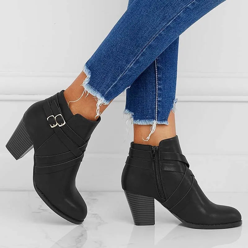 Women's grey ankle boot with a side zipper, buckle detail, and a 7cm rubber heel.