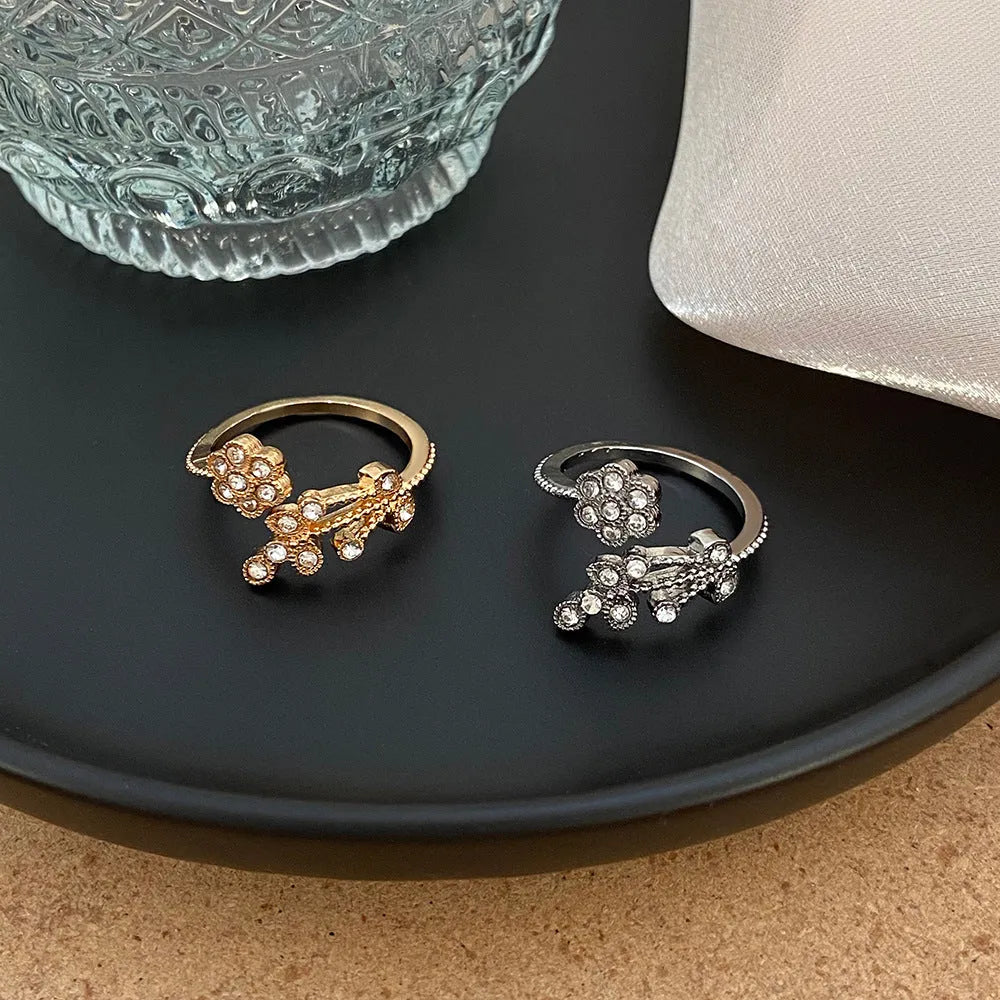 Women's open back copper ring with floral leaf design in a white diamond finish.