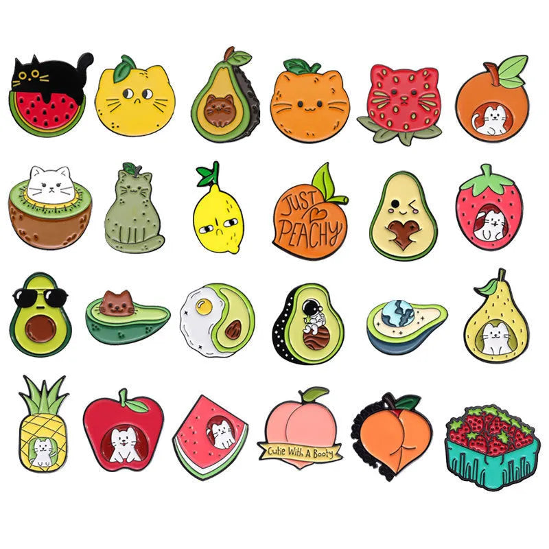 Colourful cartoon fruit and letter design metal brooch on a fabric background.