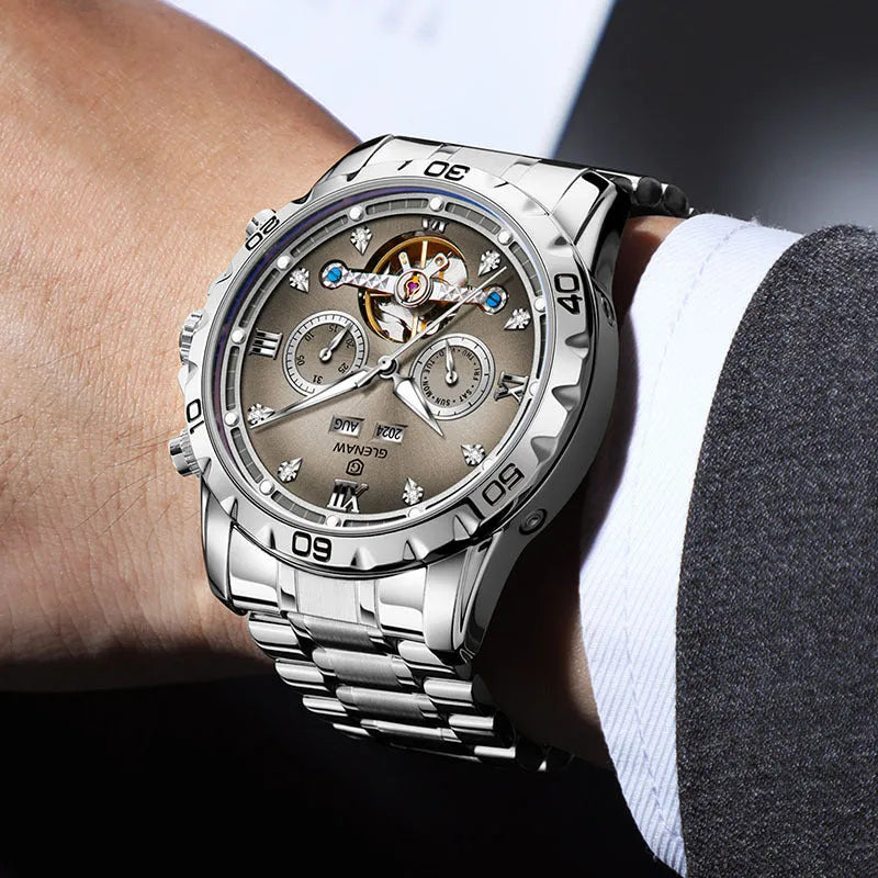 Men's automatic mechanical watch with stainless steel strap on wrist, showing blue dial and silver case variant.