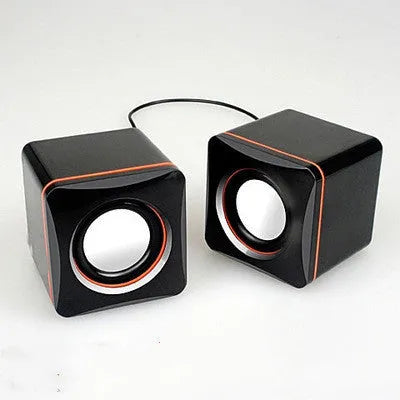 Small square black USB speaker for Model 700B computer on a desktop