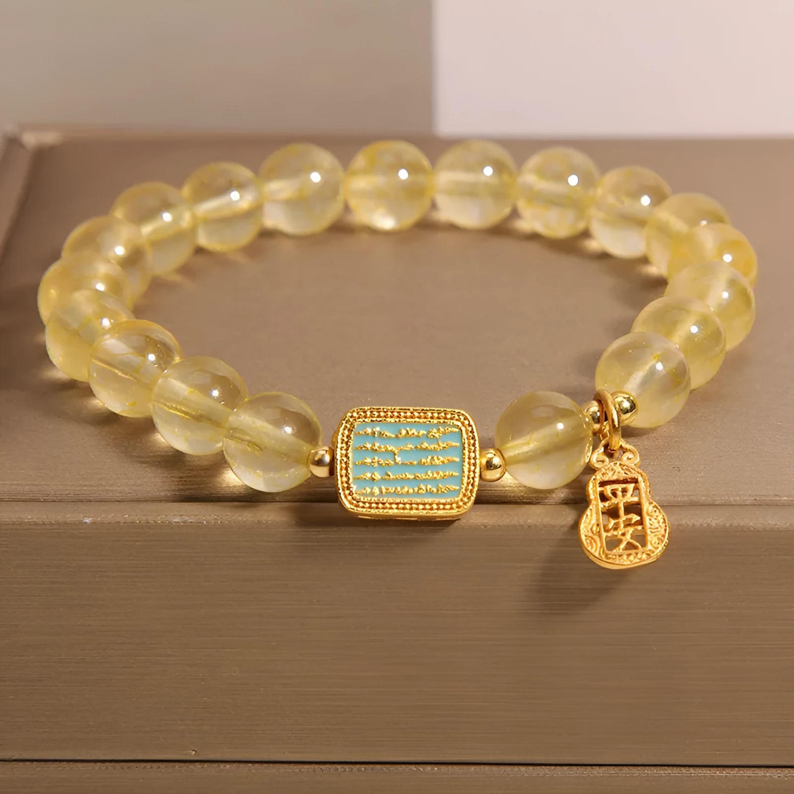 Women's yellow citrine crystal bracelet with sparkling rhinestone details on a white background.