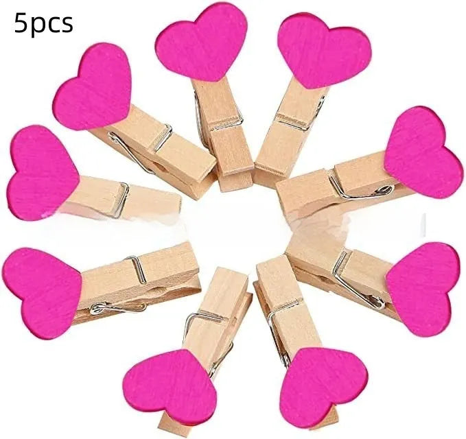 Set of five handmade solid wood heart-shaped clips in red, white, and rose red on a plain surface.