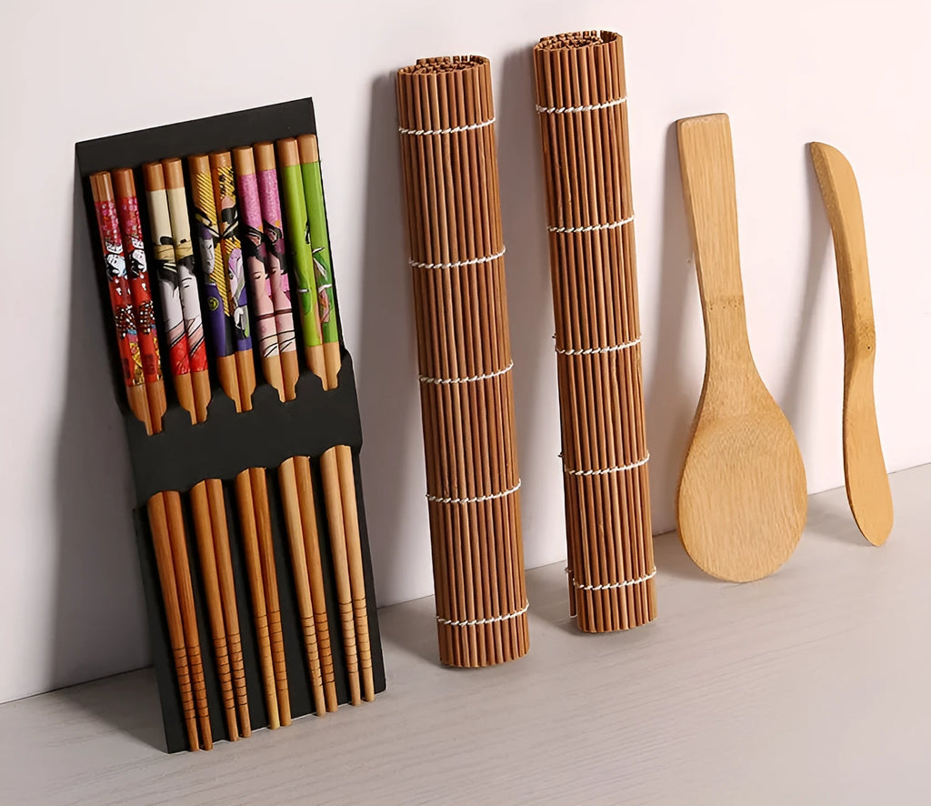 White plastic sushi tool set with moulds for rolls and Nigiri and a rice paddle on a light background