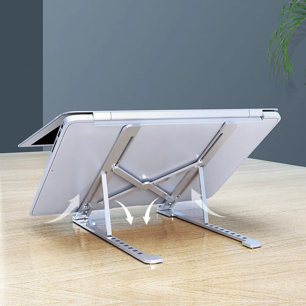 Aluminium foldable laptop stand in silver colour set to medium height with a laptop on top.