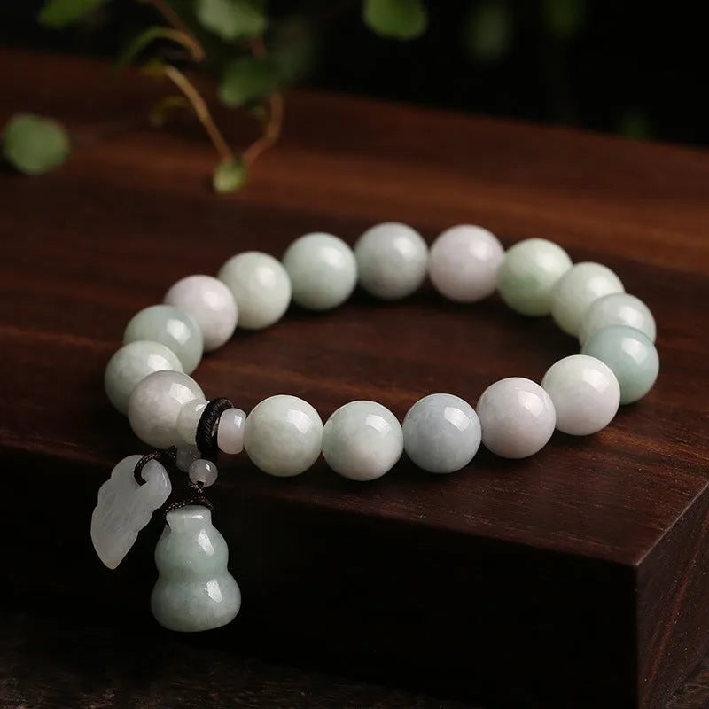 Natural green jade hanging bracelet with Maitreya Buddha pendant on a wrist.
