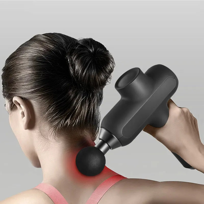 Black rechargeable massage gun with six different coloured massage heads laid out beside it.