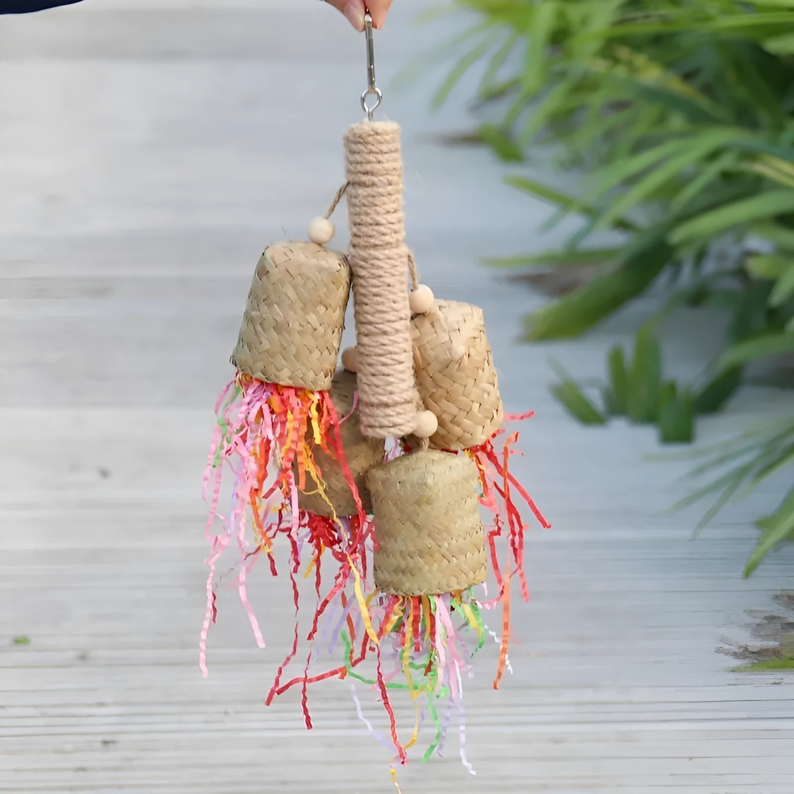 Colourful shredded paper hanging bird toy made of wood and sisal for parrots.