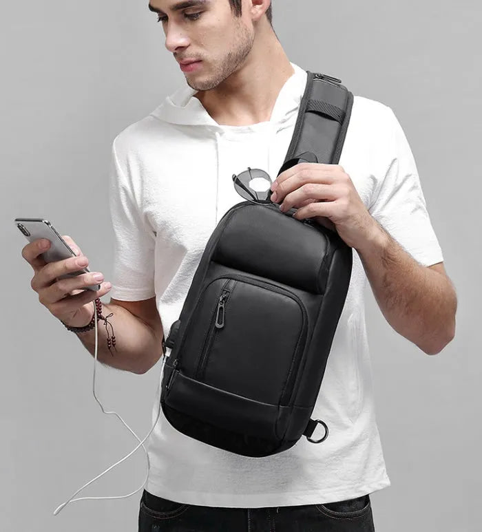 Black medium outdoor shoulder bag showing computer pocket, soft handle, and single air cushion strap.