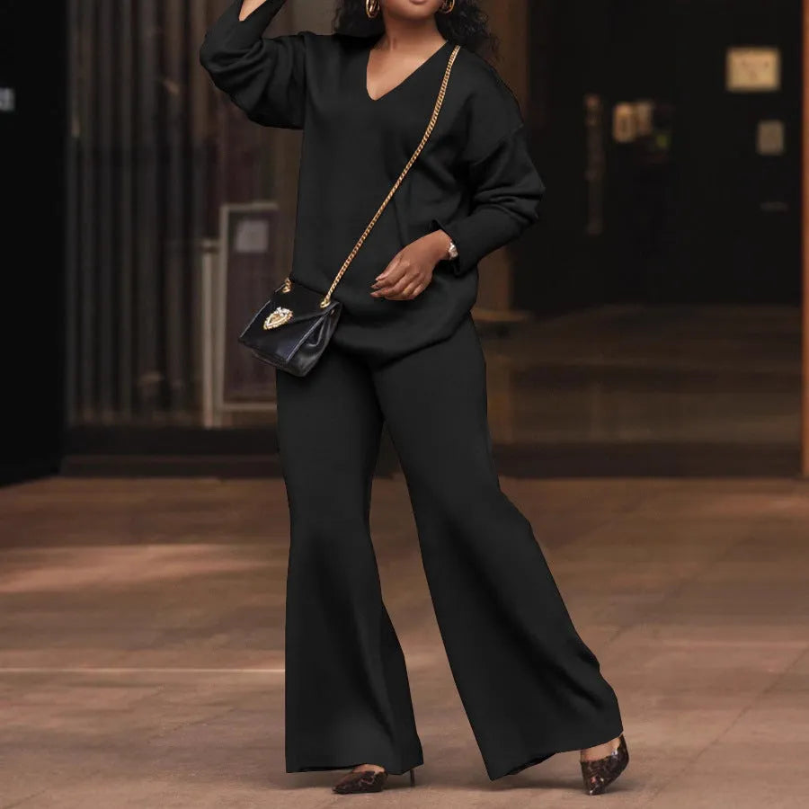 Women's brown suede two-piece suit with split sleeve top and full-length trousers on a model.
