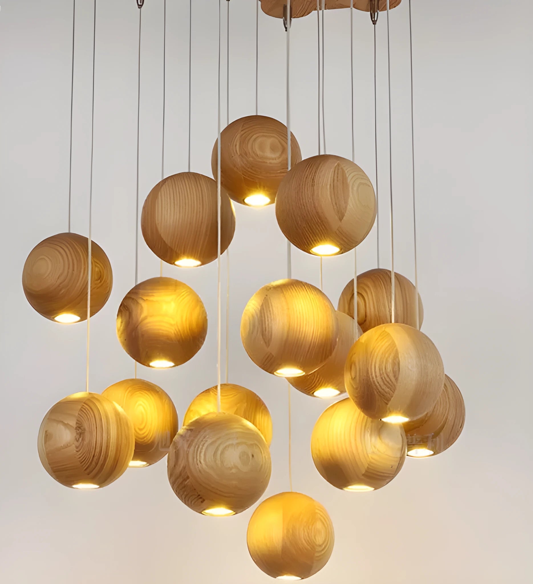 Nordic style solid wood ball chandelier pendant light hanging from ceiling on adjustable cord.