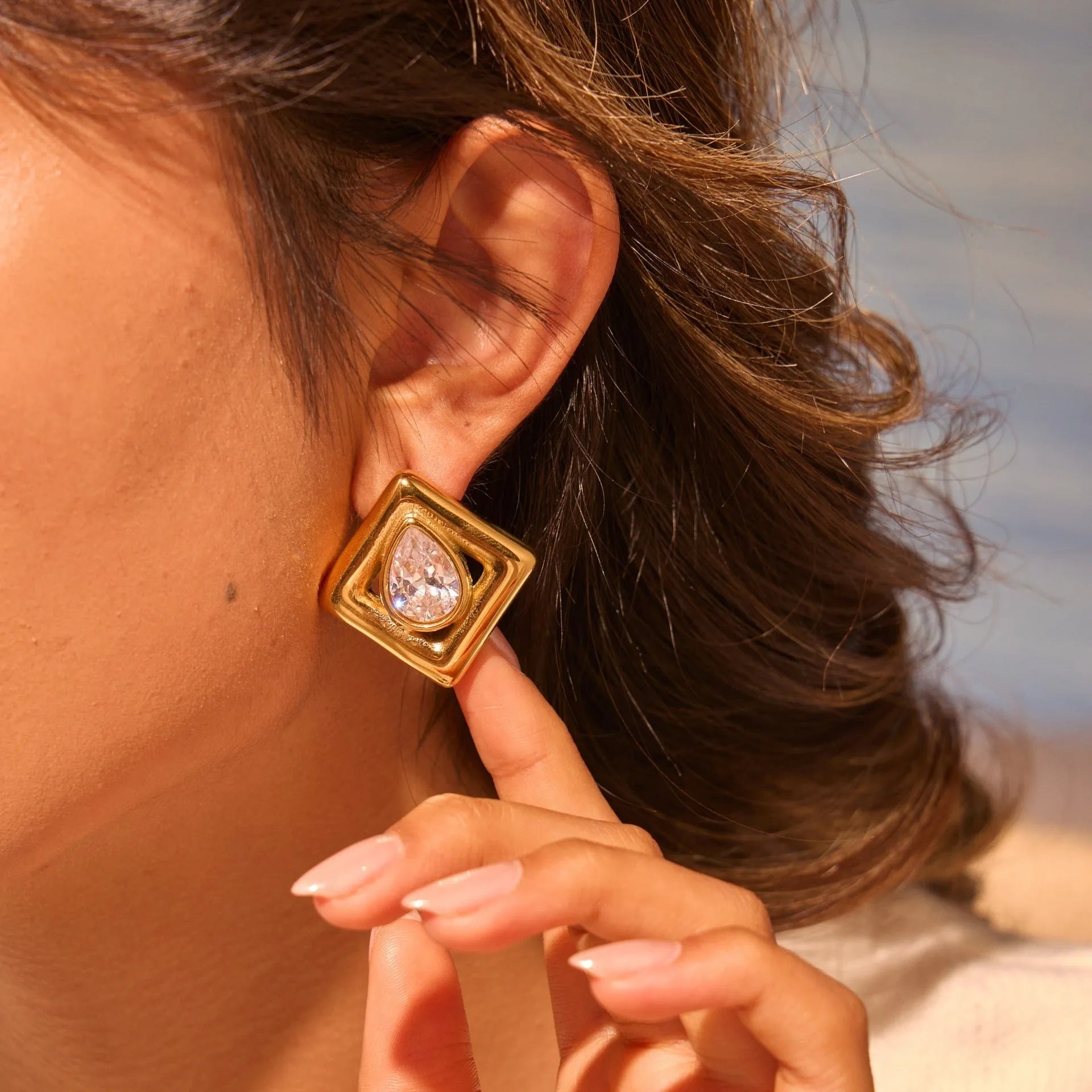 Gold-tone geometric stud earrings with inlaid water drop zircon stones on stainless steel