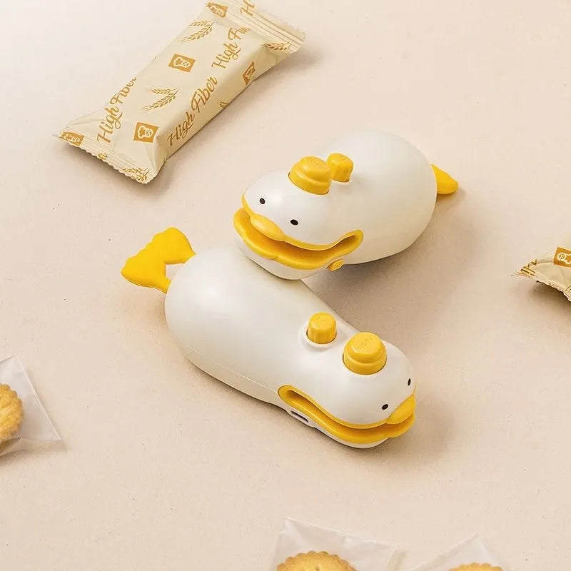 Small yellow duck animal jacquard style rechargeable sealing machine with charging cable.
