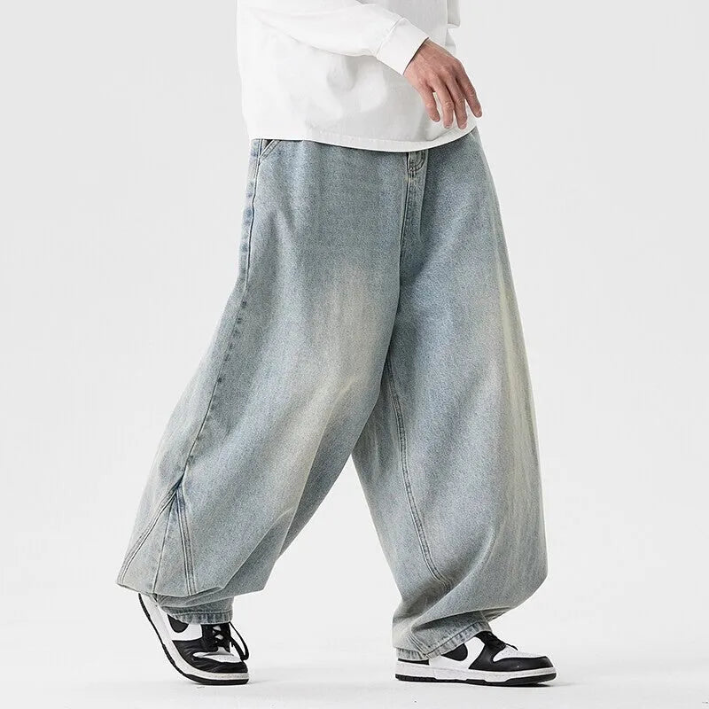 Man wearing light blue plus-size wide-leg casual denim jeans with a baggy fit and straight leg opening.