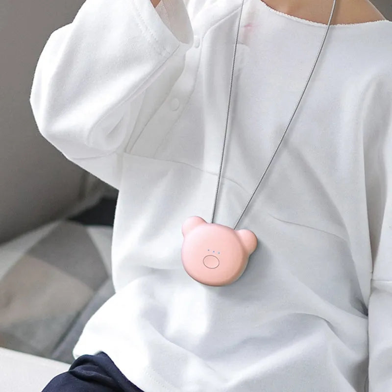 Small pink wearable USB air purifier necklace on a person, showing compact size.