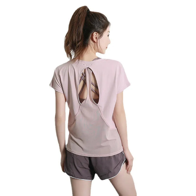 Women's short sleeve polyester sports t-shirt in pink, shown on a hanger.