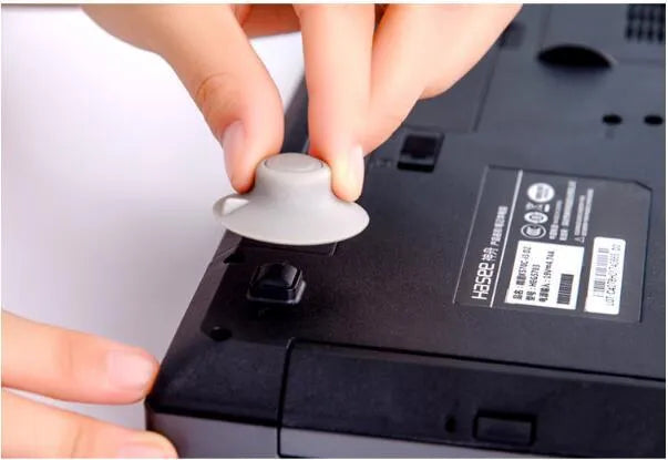 Grey plastic laptop cooling stand with four non-slip pads on a flat surface