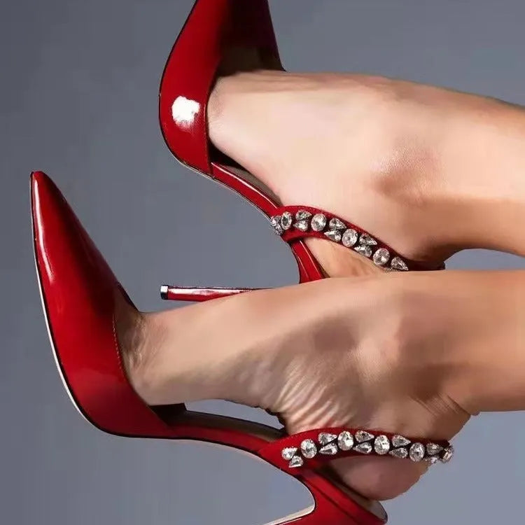 Women's black patent leather pointed toe stiletto sandals with rhinestone detail on the side, shown on a white background.