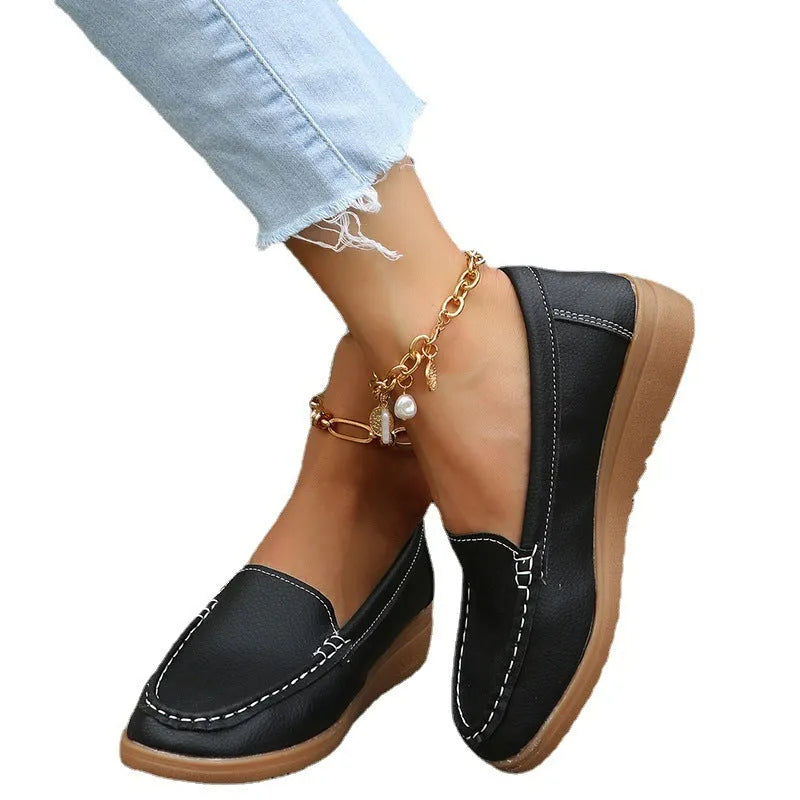 Women's black PU leather loafers with white car stitch detailing and a rubber sole.