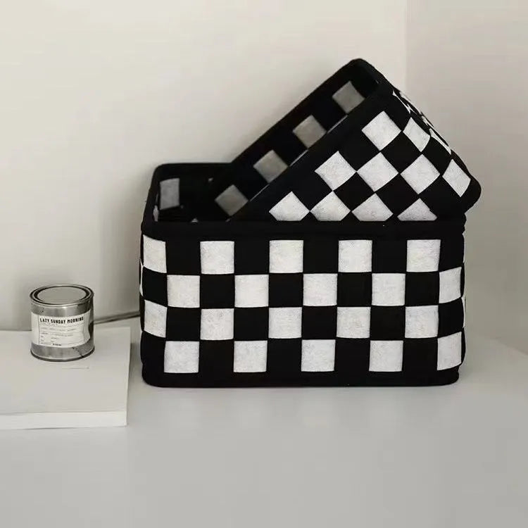 Checkerboard pattern black and white felt storage basket with folded sides.