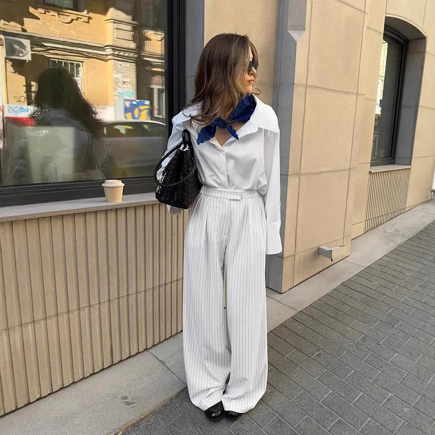 White striped wide-leg trousers with a front zip closure on a model.