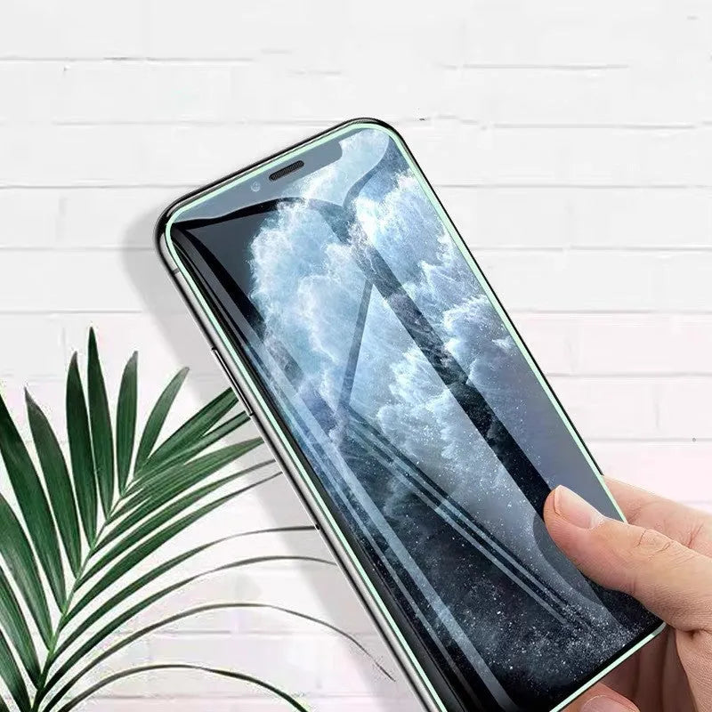 Luminous full cover tempered glass screen protector glowing green in the dark for iPhone.
